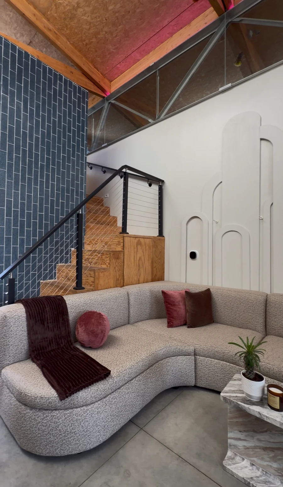 Enforma's welcoming Venice lounge with a curved sofa and warm wood details